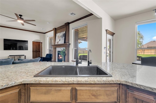 4679 Hillcrest Ln, Edmond, OK 73025 - kitchen with light stone countertops, visible vents, a sink, and a fireplace