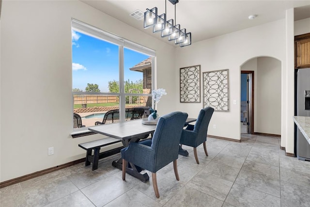 4679 Hillcrest Ln, Edmond, OK 73025 - dining space with visible vents, arched walkways, and baseboards