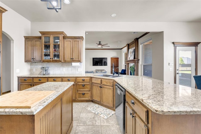 4679 Hillcrest Ln, Edmond, OK 73025 - kitchen featuring arched walkways, stainless steel dishwasher, ceiling fan, decorative backsplash, and a center island