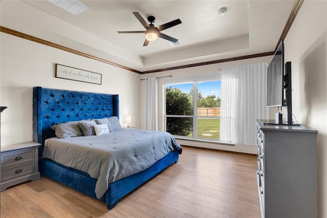 4679 Hillcrest Ln, Edmond, OK 73025 - bedroom with a tray ceiling, light wood-style floors, and ceiling fan