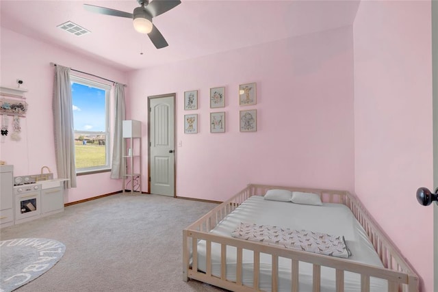 4679 Hillcrest Ln, Edmond, OK 73025 - bedroom with light colored carpet, a ceiling fan, and a crib