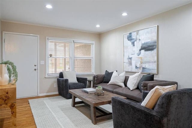 living area with recessed lighting, ornamental molding, light wood finished floors, and baseboards