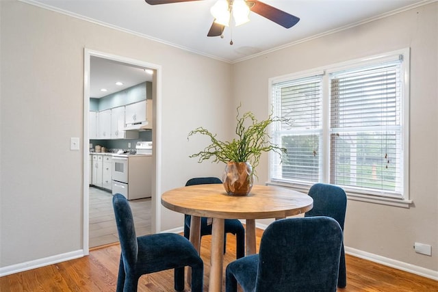 dining room with baseboards, a ceiling fan, light wood-style floors, and crown molding