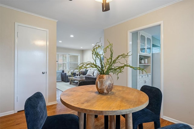 dining area with baseboards, ornamental molding, light wood finished floors, and ceiling fan