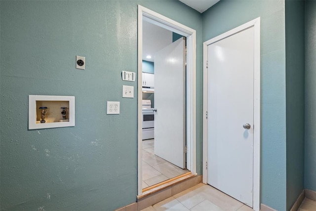 hall featuring tile patterned floors and a textured wall