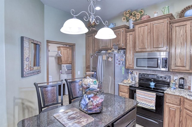 908 County St Unit 2932, Tuttle, OK 73089 - kitchen with brown cabinetry, pendant lighting, appliances with stainless steel finishes, tasteful backsplash, and dark stone countertops