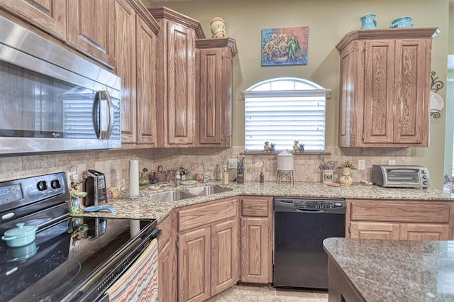 908 County St Unit 2932, Tuttle, OK 73089 - kitchen with a sink, decorative backsplash, black appliances, and light stone countertops