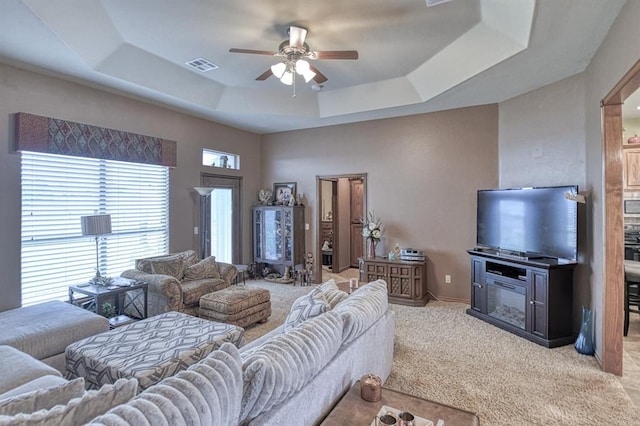 908 County St Unit 2932, Tuttle, OK 73089 - living room with visible vents, a ceiling fan, a tray ceiling, and light colored carpet