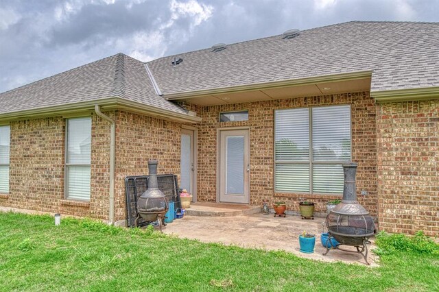 908 County St Unit 2932, Tuttle, OK 73089 - rear view of property with a shingled roof, a fire pit, and brick siding
