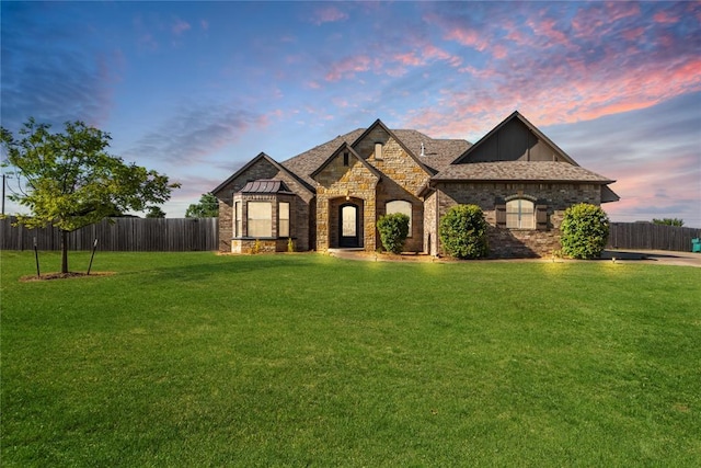 7217 SW 120th St, Oklahoma City, OK 73173 - french provincial home with a front lawn, stone siding, board and batten siding, and fence