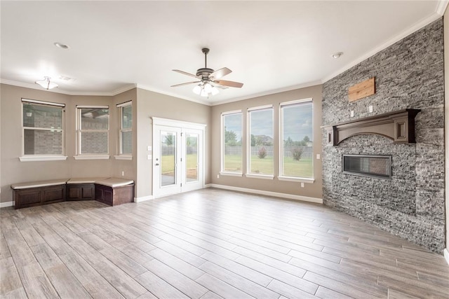 7217 SW 120th St, Oklahoma City, OK 73173 - unfurnished living room with light wood-style floors, baseboards, ceiling fan, and a stone fireplace