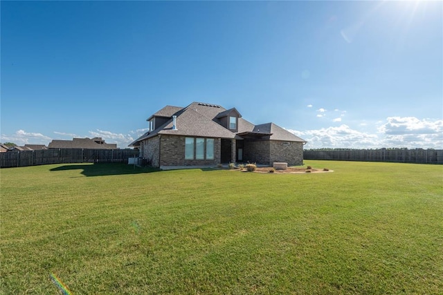 7217 SW 120th St, Oklahoma City, OK 73173 - rear view of house with a lawn, brick siding, and fence