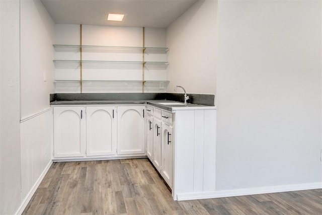 7705 Rumsey Rd, Oklahoma City, OK 73132 - bar featuring baseboards, light wood finished floors, and a sink