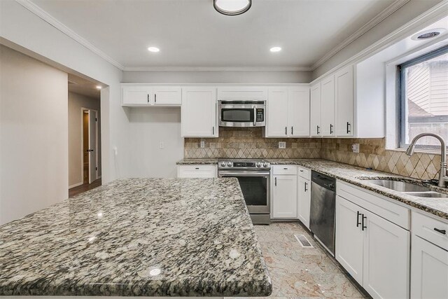 7705 Rumsey Rd, Oklahoma City, OK 73132 - kitchen featuring stainless steel appliances, light stone countertops, white cabinets, and a sink