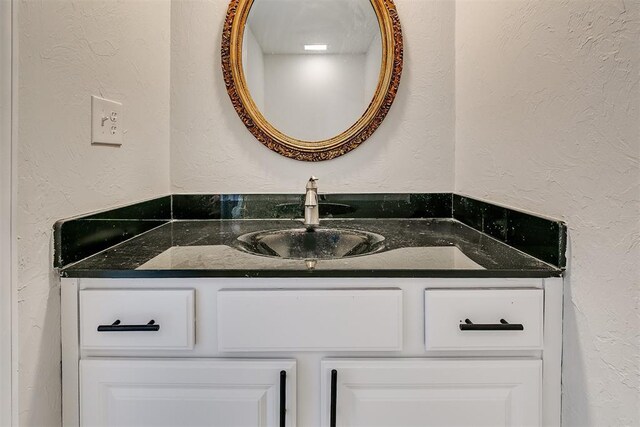 7705 Rumsey Rd, Oklahoma City, OK 73132 - bathroom featuring a textured wall and vanity