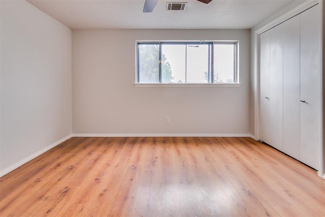 7705 Rumsey Rd, Oklahoma City, OK 73132 - unfurnished bedroom featuring visible vents, ceiling fan, a closet, baseboards, and wood finished floors