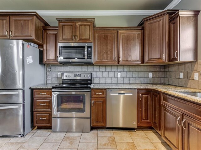 kitchen featuring crown molding, appliances with stainless steel finishes, decorative backsplash, and light stone counters