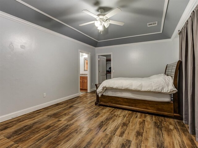 bedroom featuring ceiling fan, visible vents, baseboards, dark wood-style floors, and a tray ceiling