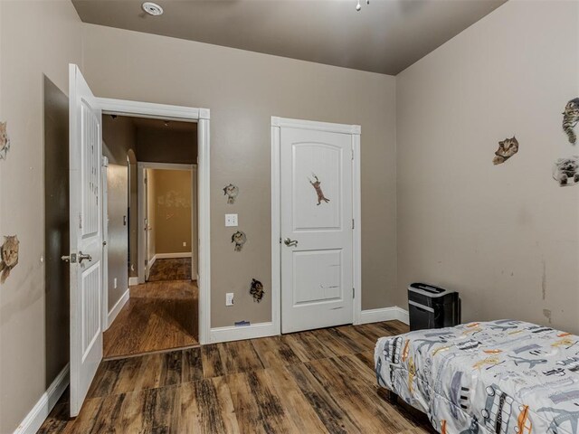 bedroom with baseboards and wood finished floors
