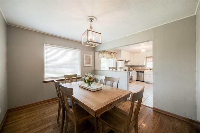 dining area with an inviting chandelier, baseboards, and plenty of natural light