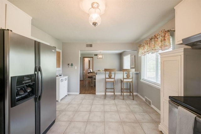 kitchen with visible vents, stainless steel refrigerator with ice dispenser, white cabinets, and light tile patterned floors