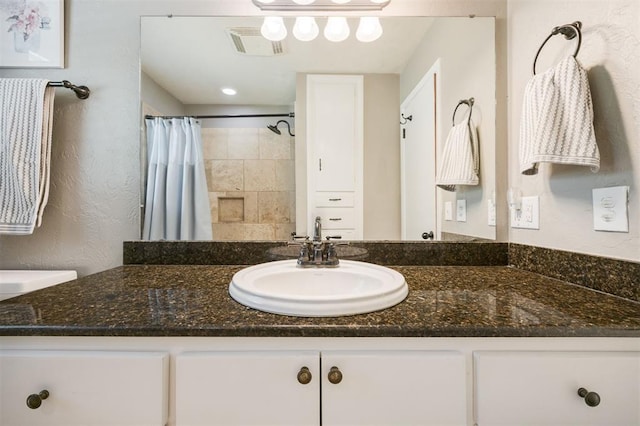 bathroom with visible vents, vanity, and curtained shower