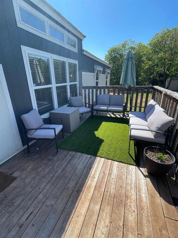 wooden deck with a yard and outdoor lounge area