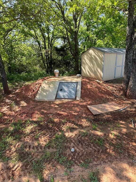 view of storm shelter with an outdoor structure and a shed