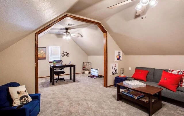 interior space featuring lofted ceiling, ceiling fan, carpet floors, and visible vents