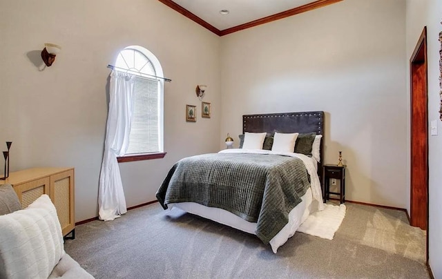 carpeted bedroom featuring crown molding and baseboards
