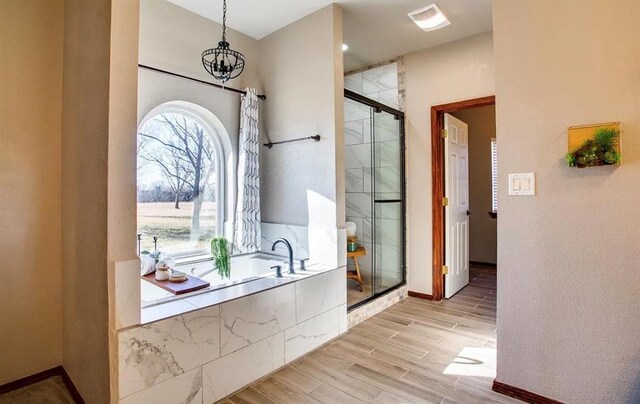 full bathroom featuring a garden tub, a shower stall, wood finished floors, and baseboards