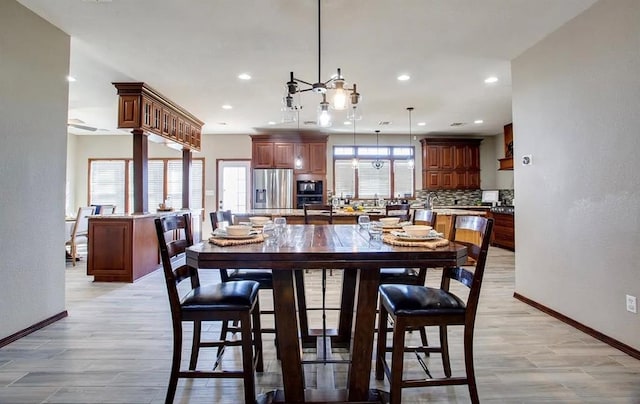 dining room with baseboards, recessed lighting, and light wood-style floors