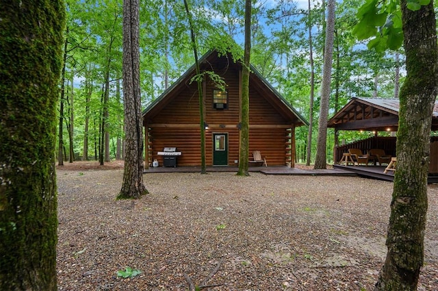 view of side of property with log siding, a gazebo, and a wooden deck