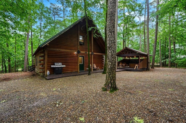 view of side of home with log siding and a detached carport