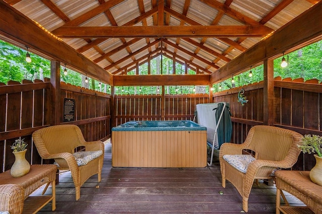 wooden deck with a gazebo, fence, and a hot tub