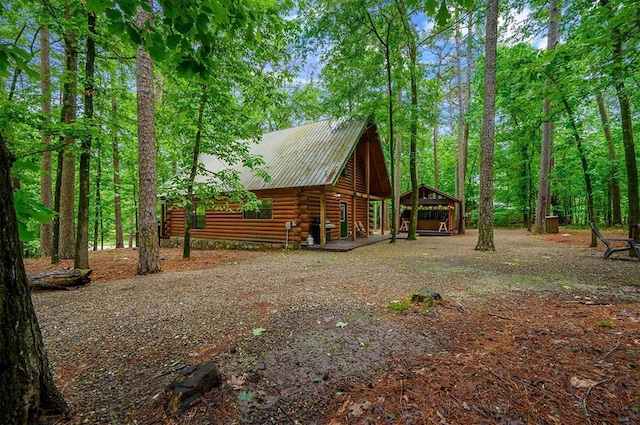 view of home's exterior featuring log exterior and metal roof