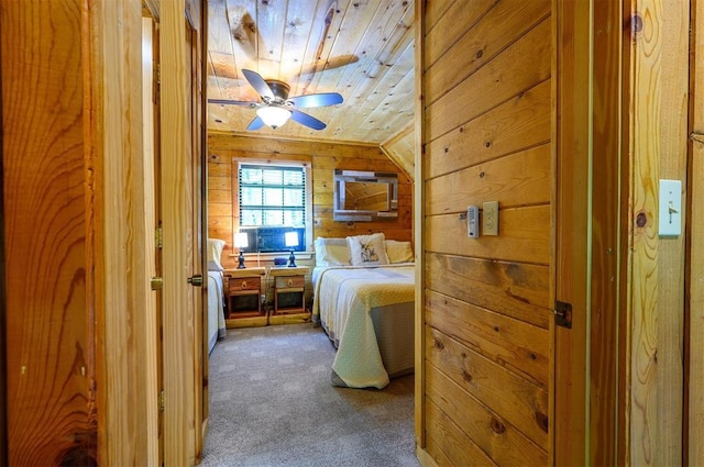 bedroom featuring dark colored carpet, wood walls, wood ceiling, and vaulted ceiling
