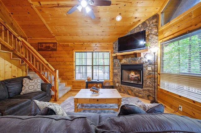 living area featuring plenty of natural light, wooden ceiling, wooden walls, wood finished floors, and stairway