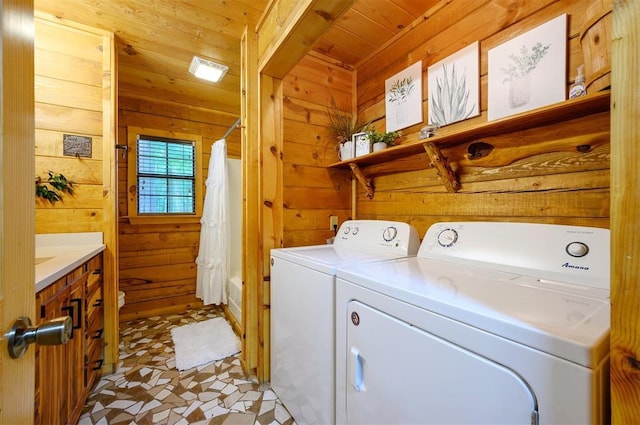 laundry room featuring wooden walls, washer and clothes dryer, and wooden ceiling