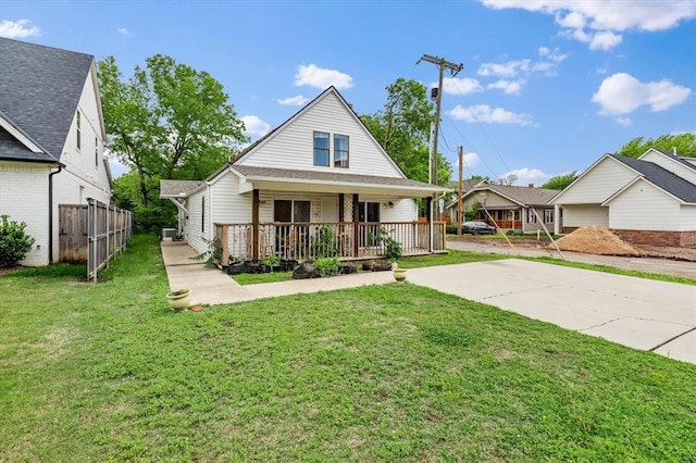view of front of property with fence, covered porch, and a front yard