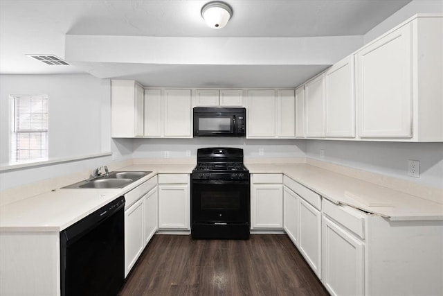 kitchen featuring black appliances, dark wood-style flooring, white cabinets, and a sink