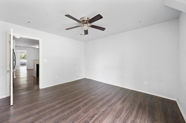 empty room featuring dark wood finished floors, baseboards, and ceiling fan