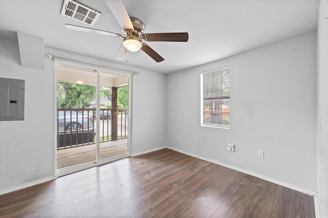 spare room featuring electric panel, a ceiling fan, visible vents, baseboards, and wood finished floors