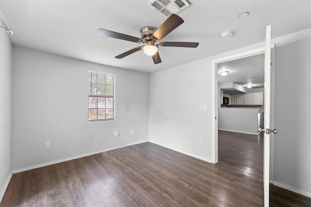 spare room featuring wood finished floors, visible vents, a ceiling fan, and baseboards