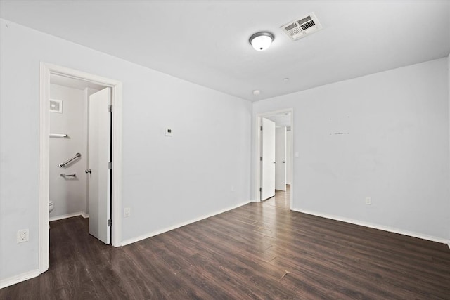 unfurnished room with visible vents, wood finished floors, and baseboards