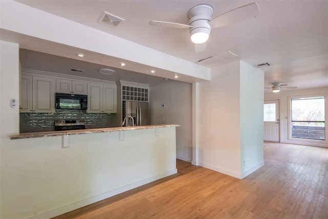 73 E Shore Dr, Arcadia, OK 73007 - kitchen featuring appliances with stainless steel finishes, visible vents, light wood-type flooring, and a ceiling fan