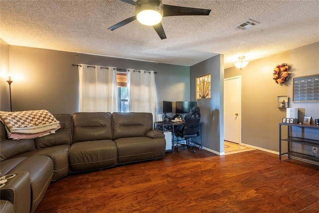 living area with a ceiling fan, visible vents, wood finished floors, and a textured ceiling