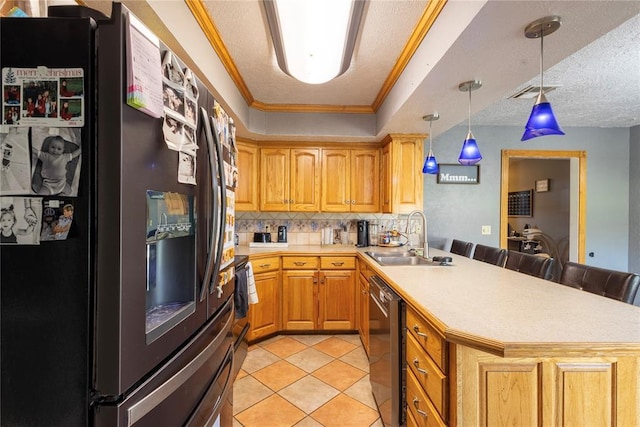kitchen featuring a sink, stainless steel appliances, light countertops, a peninsula, and backsplash