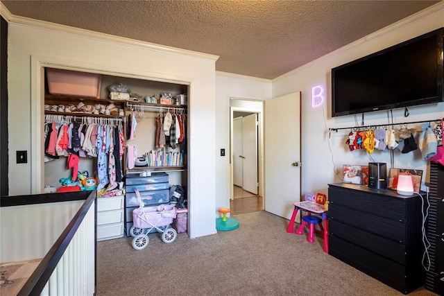 bedroom with a textured ceiling, crown molding, carpet flooring, and a closet