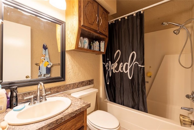 bathroom with toilet, shower / bathtub combination with curtain, a textured wall, and vanity